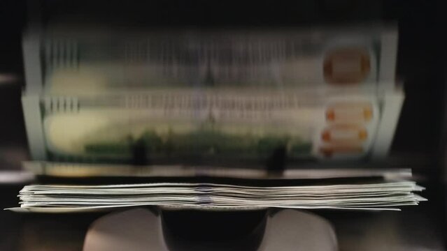 USD dollars cash deposit machine. Close up of currency counting machine counting new dollar bills. Machine counter automatic calculates a large amount of Dollar banknotes in 4k Slow motion 100fps