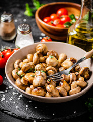 Fried mushrooms in a bowl with cherry tomatoes. 