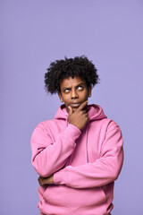 Fototapeta na wymiar Young thoughtful confused African American teen guy student thinking holding hand on chin, looking up, choosing, making decision, feeling doubt, having question isolated on purple background.