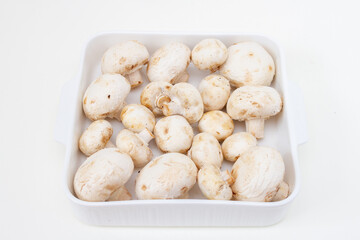 Fresh champignon mushrooms in a white plate. step-by-step recipe for cooking stuffed mushrooms. Step 2