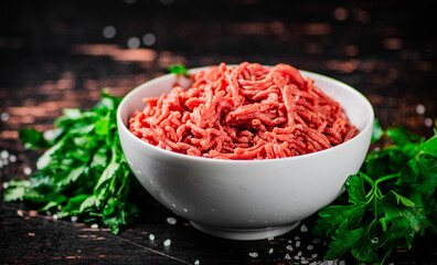 Minced fresh meat in a bowl with parsley. 