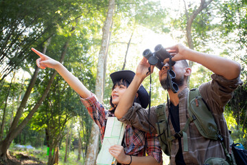 Fototapeta premium Family with father and daughter tourist backpack hiking doing activity while father looking binoculars in holiday together, man and teenager woman journey adventure trip and looking map.