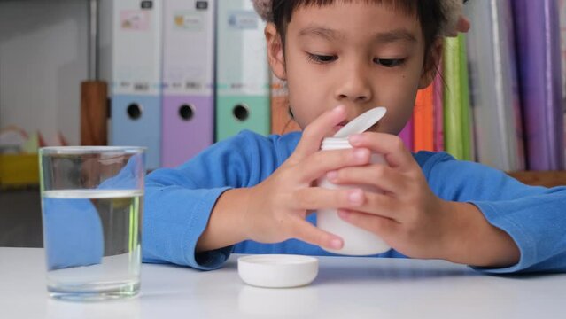 Cute little girl eating alpha omega 3 or Vitamin pill. Vitamin supplements for children for better immunity.