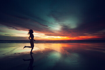 Woman running on beach sunset