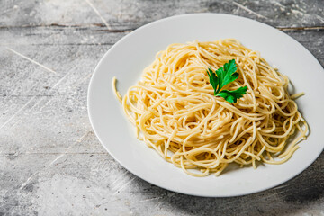 Boiled spaghetti in a plate with parsley. 
