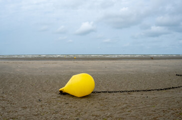 Yellow buoy on the beach on the shoreline
