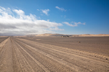 Fototapeta na wymiar Gravel road with dunes in Skeleton Coast Park, Namibia. 