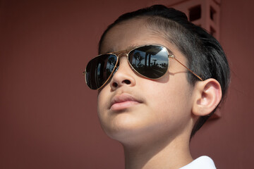 British Indian teenage boy in sunglasses on a sunny day. 