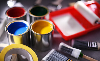 Paintbrushes of different size and paint cans