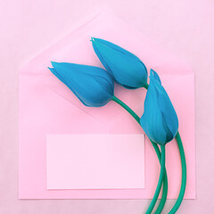 Minimalistic postcard with a bouquet of tulips in an envelope