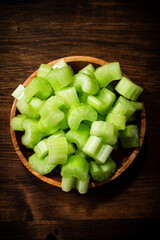 A wooden plate with a piece of celery. 