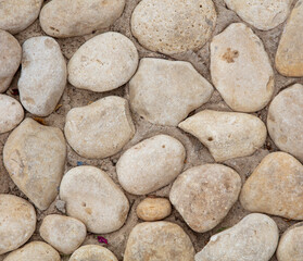 Fototapeta na wymiar Stones in a concrete wall as an abstract background.