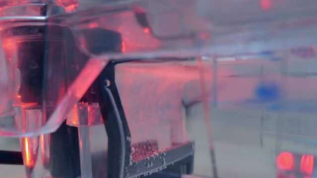 Gas bubbles from the anode-cathode in the buffer during electrophoresis, bubbles illuminated by light.