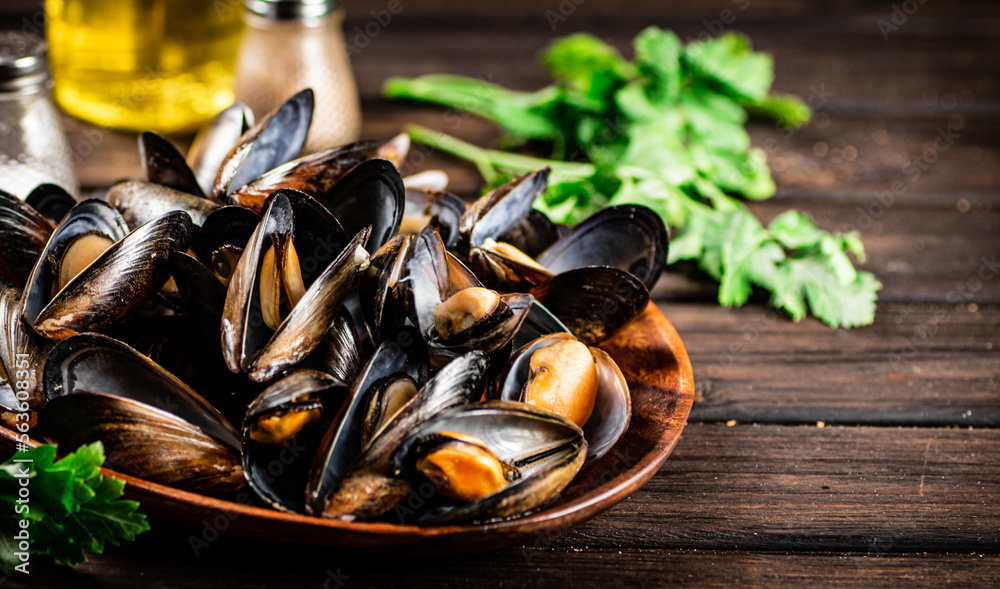 Poster boiled mussels in a plate with parsley.