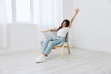 Woman relaxing at home and sipping her hands sitting in a chair with her laptop, lifestyle homemade spirits. Mockup, free copy space