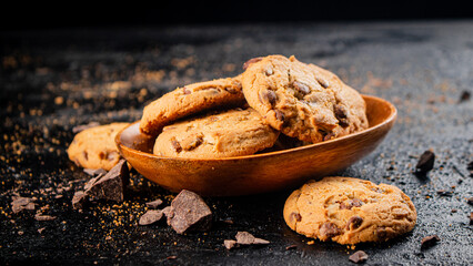 Wooden plate with cookies and pieces of milk chocolate. 