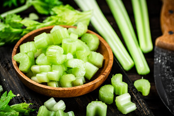 Sliced fresh celery. On a dark wooden background.