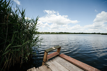 Naklejka premium Big lake on the horizon with trees and reeds.