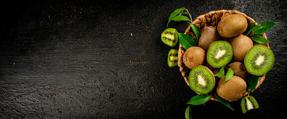 Fresh kiwi with leaves in a basket. 