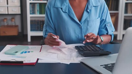 Close up woman accountant hands using calculator and cashier checks to prepare financial statements and look for opportunities to optimize costs sits at table with laptop in office