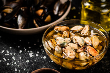 Pickled mussels in a glass bowl with spices. 