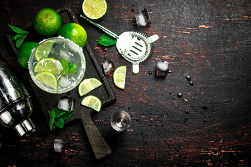 Margarita on a cutting board with pieces of lime and mint leaves. 