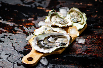 Oysters on a wooden cutting board. 