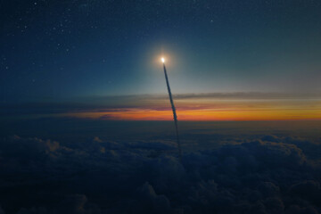 Space rocket shuttle with blast and smoke flies through clouds into starry space at sunset....