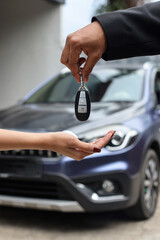 Close-up image hands of client buys a car and receives keys from the seller.