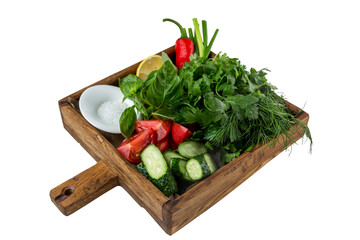 A variety of greens with fresh vegetables and salt in a wooden plate. Appetizing appetizer for lunch. Close-up. Isolated on white background.
