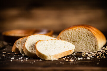 Sliced wheat bread. On a wooden background.