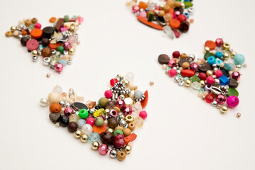 Frame in the shape of hearts. Background of multicolored decorative craft beads. Valentine's Day. Symbol of love.
