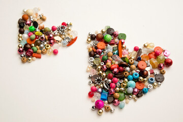 Frame in the shape of hearts. Background of multicolored decorative craft beads. Valentine's Day. Symbol of love.
