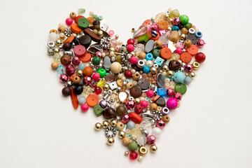 Frame in the shape of hearts. Background of multicolored decorative craft beads. Valentine's Day. Symbol of love.

