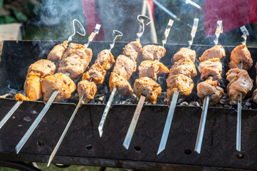 Shashlik during of cooking on the mangal over hot charcoals outdoors, street food
