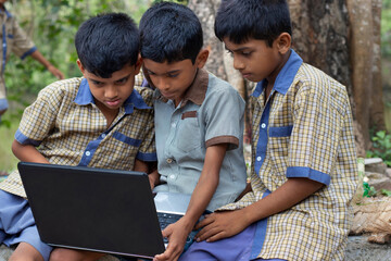 indian village government school boys operating laptop computer system at rural area in india