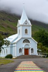 Fototapeta na wymiar Seydisfjördur, Iceland - July 23, 2022: Rainbow road towards the church