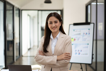 Confident Latin business leader portrait, Young businesswoman in suit posing with arms folded, looking at camera and smiling. Female leadership concept.