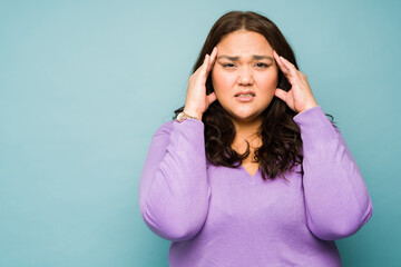 Obraz na płótnie Canvas Stressed tired fat woman having a bad headache
