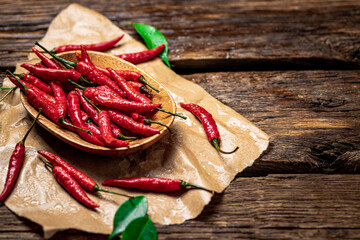 Hot chili peppers with leaves on a plate.