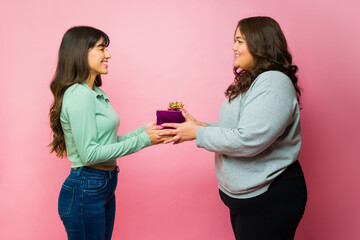 Beautiful woman giving her best friend a present
