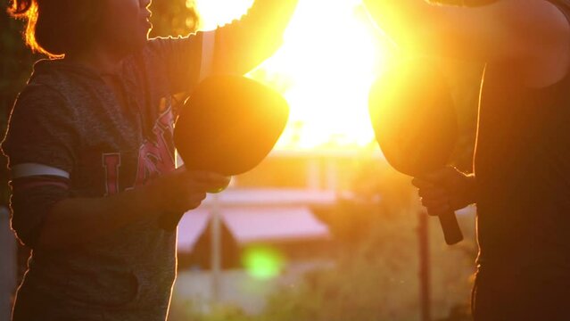 They were having fun playing pickleball at sunset