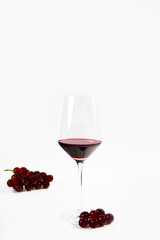 Wine Glass with a splash of red wine and grapes isolated on white background copy space