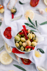 Various olives flavored with spices in white cup and glass jar. Green olives, black olives. Front and top shot on a white background