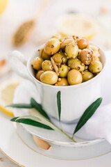 Various olives flavored with spices in white cup and glass jar. Green olives, black olives. Front and top shot on a white background