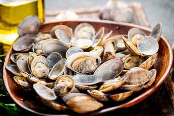 A wooden plate full of fresh vongole. 