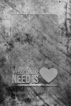 Napis "All ypu need is love" na czarno-białym tle z mocną fakturą. Vintage tło z rysami