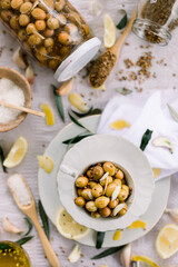 Various olives flavored with spices in white cup and glass jar. Green olives, black olives. Front and top shot on a white background