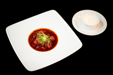 close up of a good serving from the chef of a delicious Ukrainian national dish boshch with sour cream