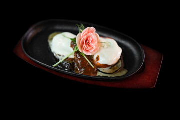 close up of an exquisite serving of a special dish from the chef on a black plate